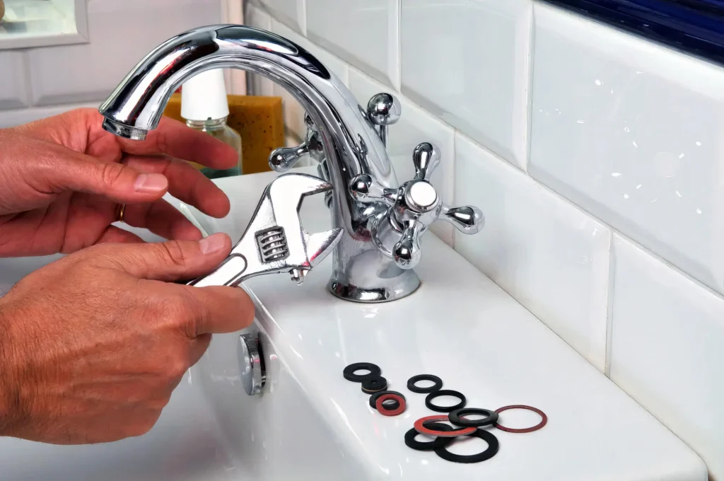 Plumber performing maintenance on a bathroom faucet in Vero Beach