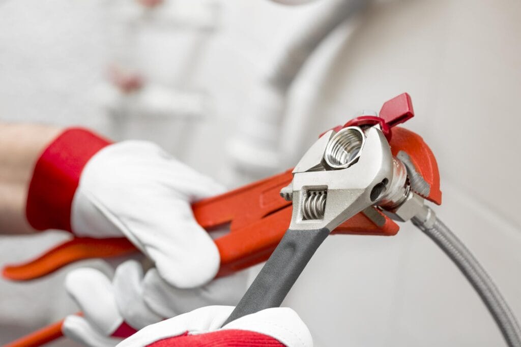 Plumber holding pipe wrenches for an emergency repair in Vero Beach