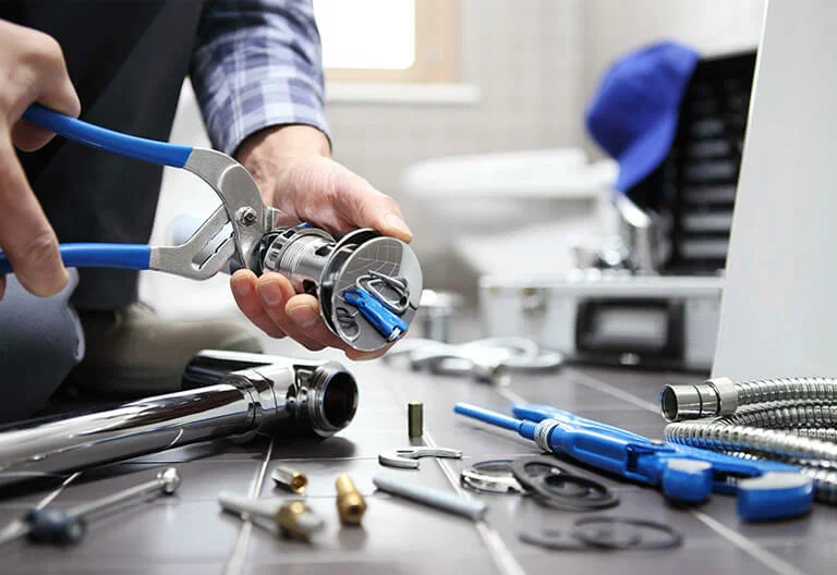 Technician repairing a plumbing fixture with professional tools in Vero Beach