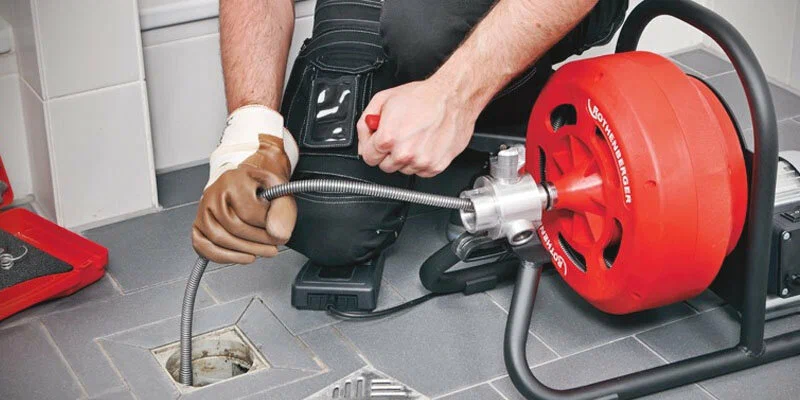 Plumber using a drain-cleaning machine in Vero Beach