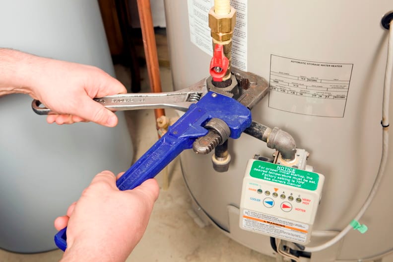 Plumber repairing a water heater valve in Vero Beach